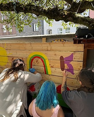 Auszubildende beim Bemalen einer Holzwand