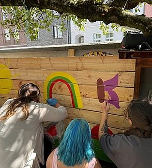Auszubildende beim Bemalen einer Holzwand